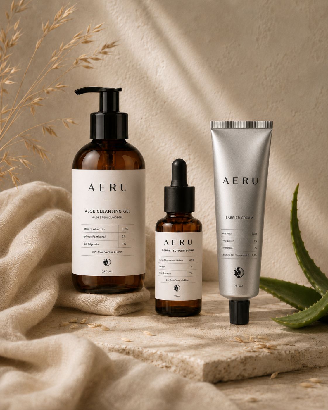 AERU Routine-Set: Aloe Cleansing Gel, Barrier Support Serum und Barrier Cream auf hellem Stein, daneben ein Aloe-Blatt